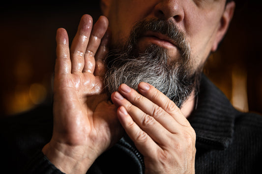 Close up of bearded man with oil on his hands
